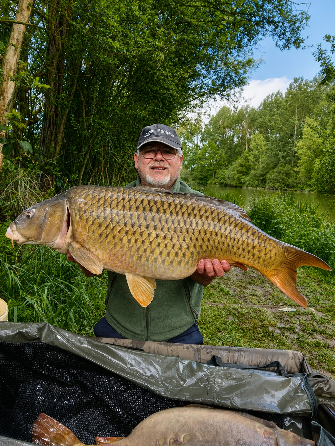 Angler with a trophy carp at golden hour